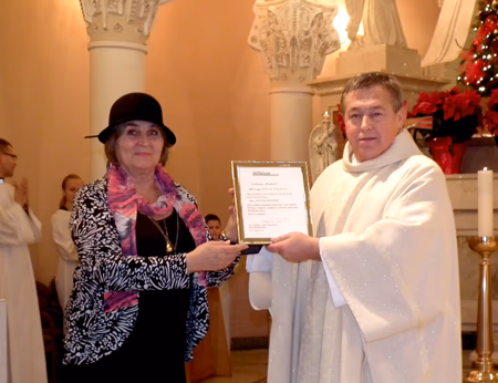 Kun. Jauniui Kelpšai „Metų žmogaus” apdovanojimą įteikia „Bičiulystės” vyr.redaktorė Ligija Tautkuvienė. Stefos Tamoševičienės nuotr.