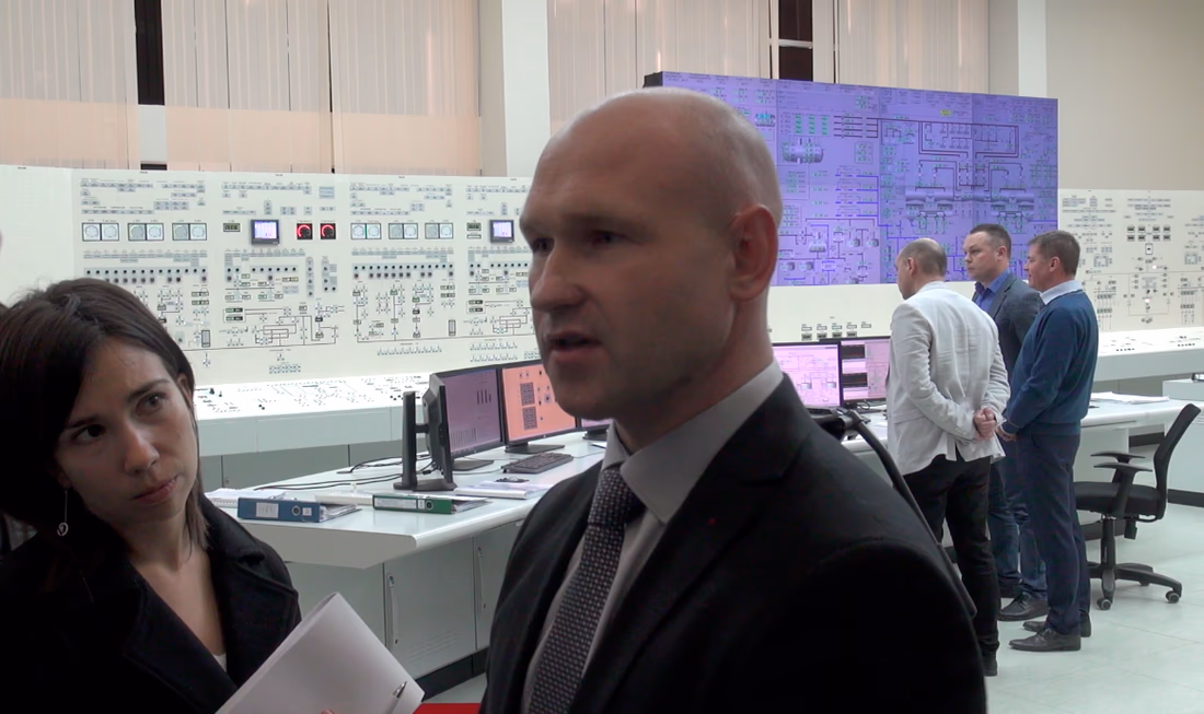 Kadras iš Baltarusijos atominės elektrinės mokomosios centrinio valdymo pulto patalpos. Į Vengrijos žurnalistės klausimą atsako elektrinės specialistas. Nuotr. E.eu