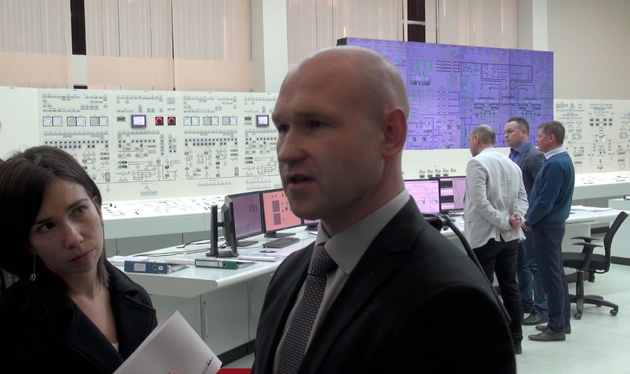 Kadras iš Baltarusijos atominės elektrinės mokomosios centrinio valdymo pulto patalpos. Į Vengrijos žurnalistės klausimą atsako elektrinės specialistas. Nuotr. E.eu