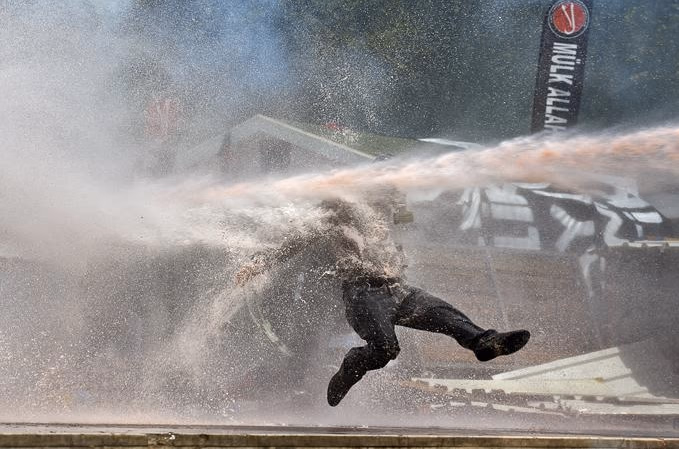 Paveiktas vandens patrankos žmogus akimirkai gali pajusti lengvą nesvarumo būseną, todėl noras protestuoti kuriam laikui nuslopsta. Nuotr. aljazeera.com