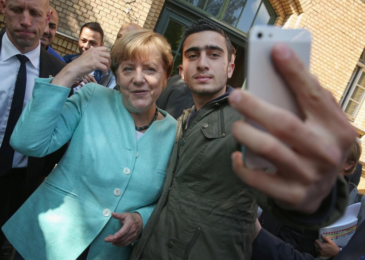 A. Merkel paveiksluojasi su pabėgėliu.