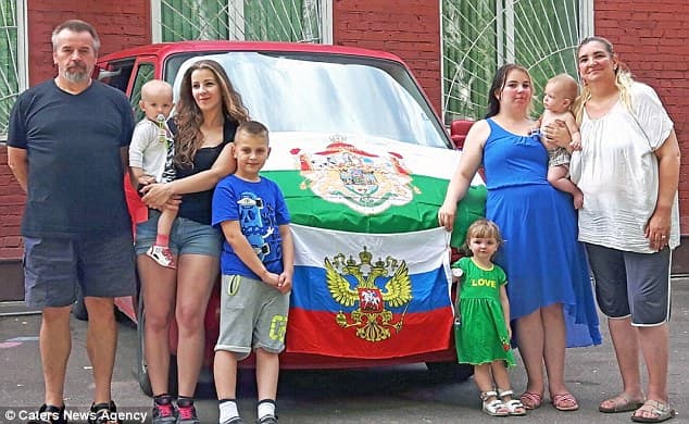 Nuo Vokietijos diktatūros į Rusiją pabėgusi vokiečių Grisbachų šeima su vaikais ir anūkais, Rusijos ir gimtosios Saksonijos vėliavomis.