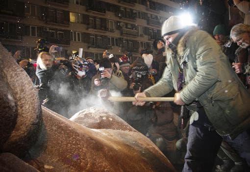 Protestuotojai nuvertė ir suskaldė paminklą Leninui, jo gabaliukus minia pasiima atminčiai