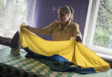 Moteris lygina šalies vėliavą rinkimų apylinkėje kaime Donecko srityje. EPA-ELTA nuotr.