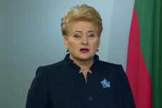 Laisvės kovų dalyvė D. Grybauskaitė įsisega mėlyną gėlę tam, kad prisimintų, kodėl mes esame laisvi.